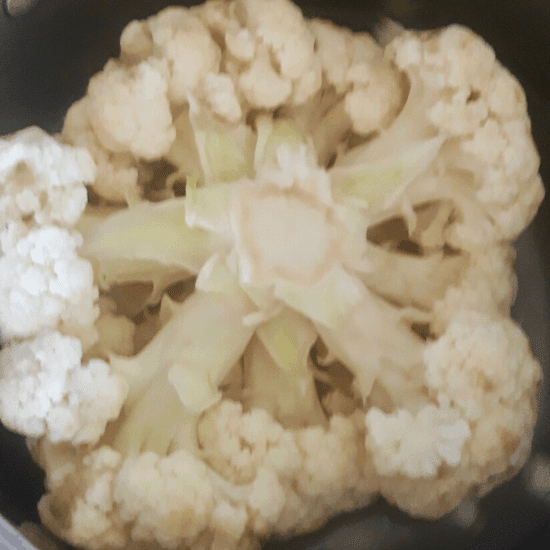 Boiling a head of cauliflower for Gobi Musallam