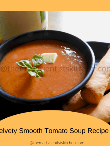 A serving of tomato soup with home grown basi and a dollop of butter