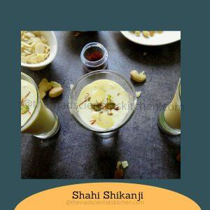 Glass of chilled Shahi Shikanji with a vibrant mix of dry fruits on top.
