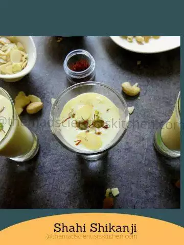 Glass of chilled Shahi Shikanji with a vibrant mix of dry fruits on top.